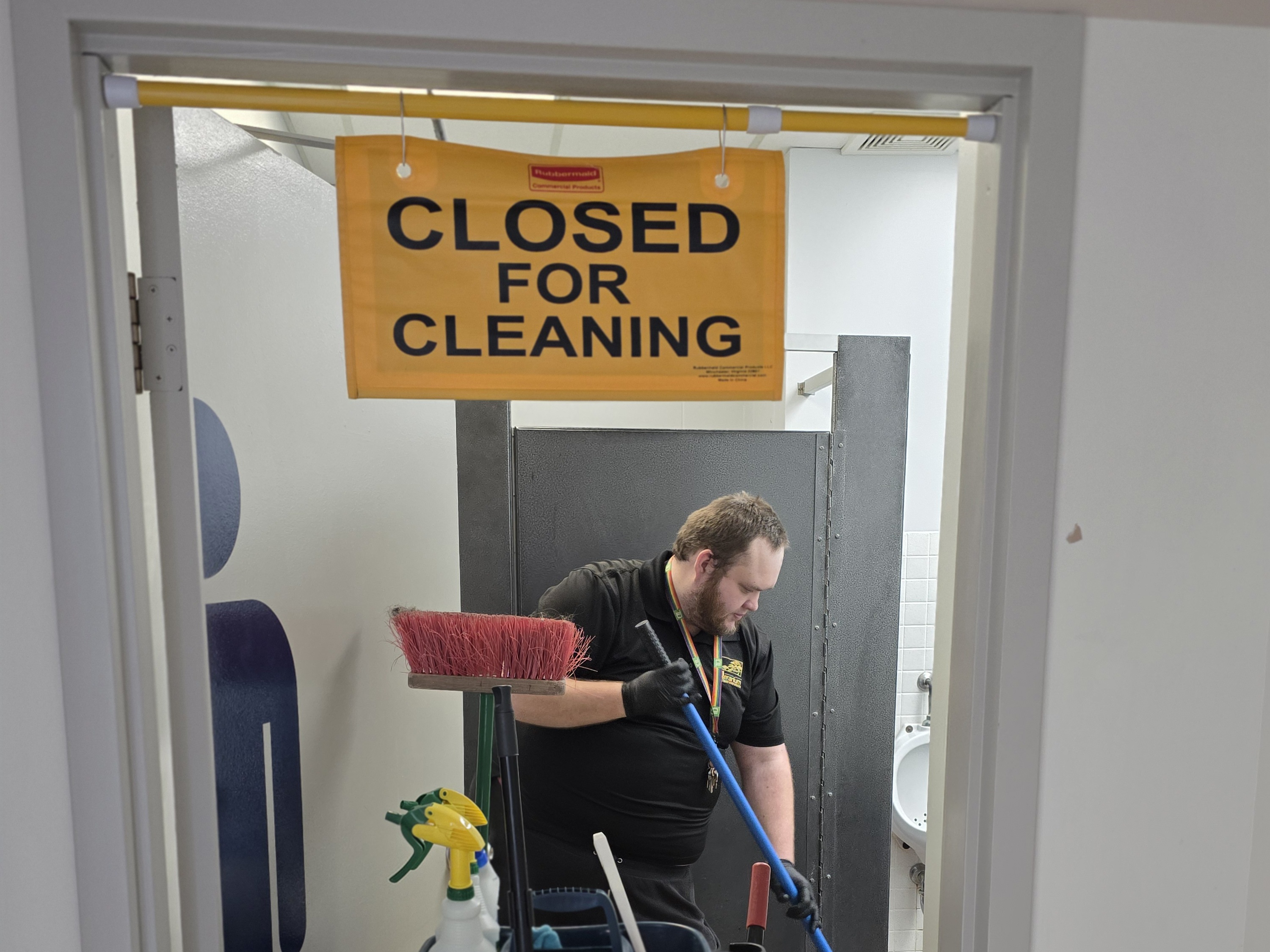A Control Janitorial Barrie day porter cleaning a restroom during business hours.